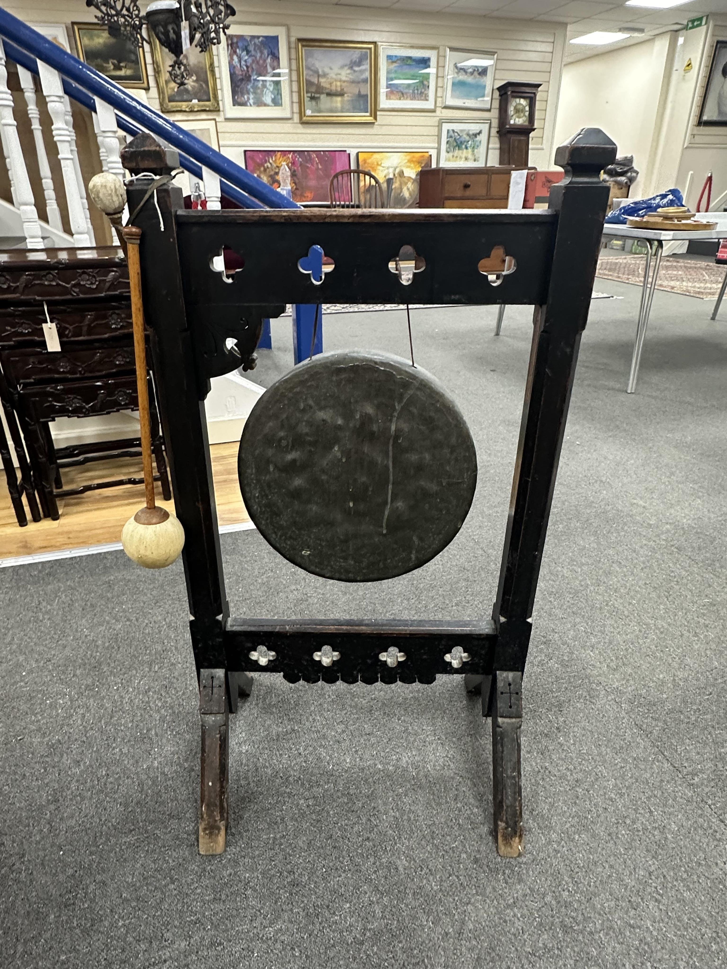 A late Victorian Gothic Revival oak dinner gong with strikers, width 50cm, height 94cm. Condition - fair